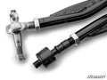 Close-up of two black metal tie rods from the Can-Am Defender HD10 RackBoss 2.0 Z-Bend Tie Rod Kit, featuring silver ball joints and bolts at the ends; one end has a threaded rod, the other a black cylindrical attachment. SuperATV logo bottom right.
