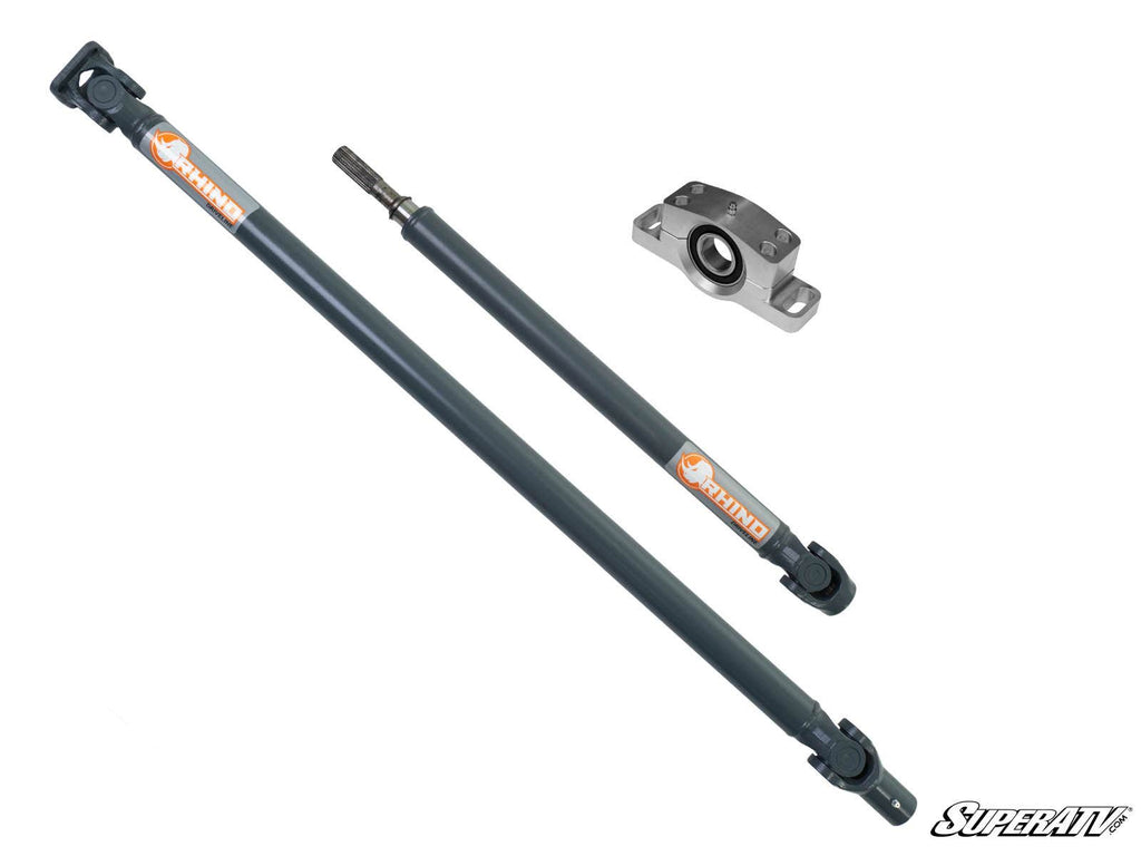 Two dark gray Polaris RZR XP Turbo Heavy-Duty Prop ShaftRhino Driveline shafts with orange and white “Rhino” labels are shown diagonally beside a silver bearing housing with a black center on a plain white background. “SuperATV” is at the bottom right.