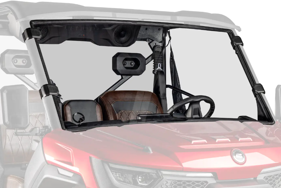 A close-up of the CFMOTO UForce U10 Pro with its scratch resistant windshield, brown leather seats, steering wheel, and overhead speakers. Set against a plain white background highlighting the front interior and dashboard.