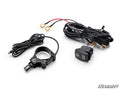 The Assault Industries UTV Dome Light is shown on a white background, featuring black cables with connectors and ring terminals, a handlebar-mounted control bracket, and a rocker switch. The “SuperATV” logo appears in the bottom right corner.