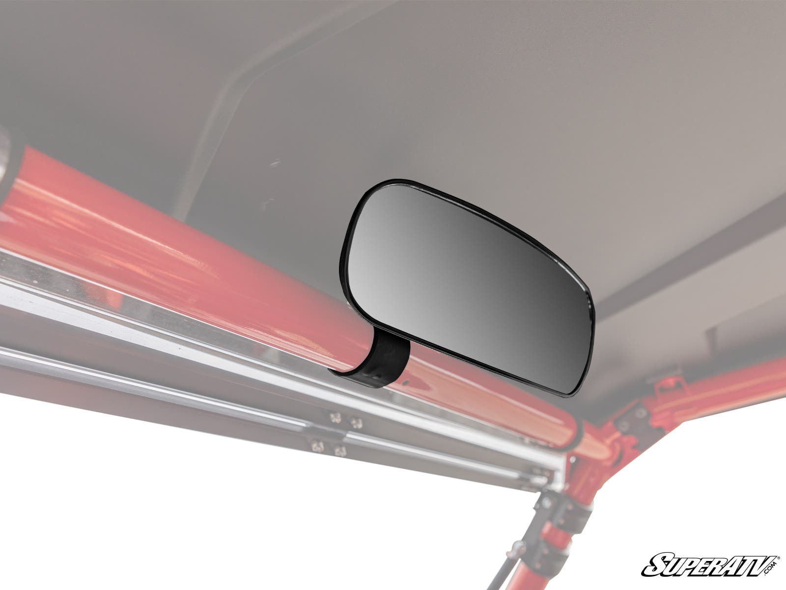 The CFMOTO Rear View Mirror is mounted to a red metal roll bar inside a vehicle with a gray roof. This rectangular mirror with rounded edges uses a black clamp for attachment and features the SuperATV logo in the bottom right corner.