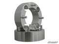 Two metallic, cylindrical Suzuki 2 Wheel Spacer - 4/110 units with threaded studs are stacked vertically on a plain white background. Their shiny machined surfaces reflect light. The SuperATV logo appears in the bottom right corner.