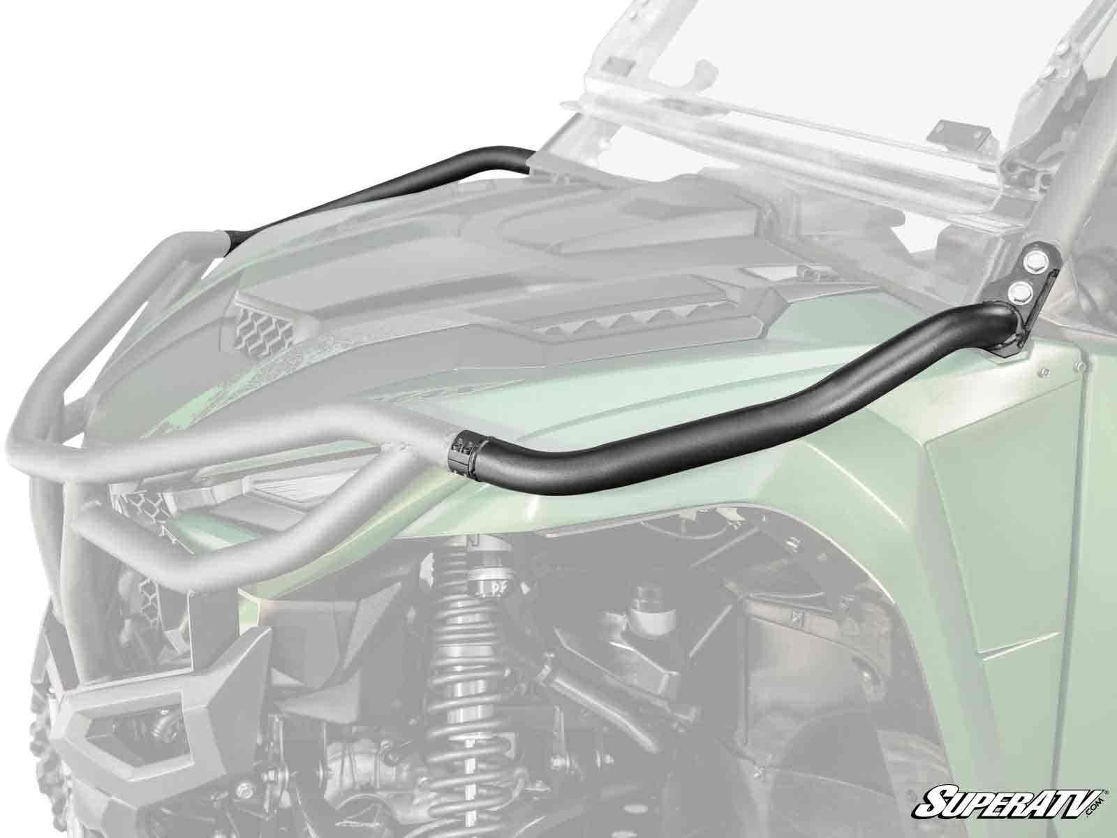Close-up of a green off-road vehicle equipped with Yamaha Wolverine RMAX 1000 Tubed Fender Guards, featuring sturdy black metal tubes that curve along the hood and are mounted near the windshield; SuperATV branding appears in the bottom right corner.