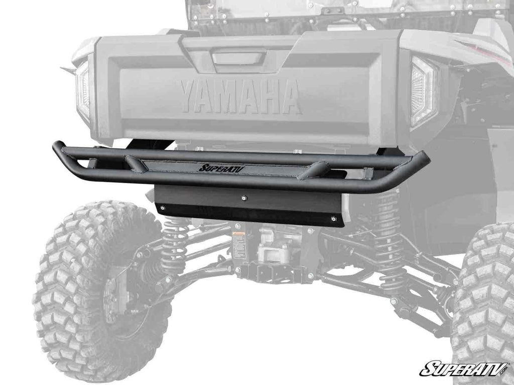 A Yamaha Wolverine RMAX 1000 Rear Bumper is installed on a Yamaha off-road vehicle. The rugged tires and suspension are visible, with “Yamaha” embossed above the bumper. A partial grayscale background draws attention to the bumper.