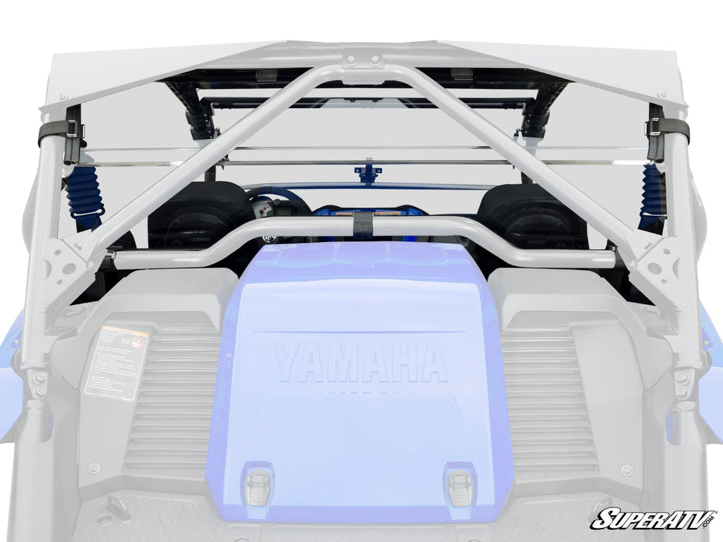 Rear view of a blue Yamaha YXZ with gray SuperATV roll cage, support bars, and visible suspension springs and seats. The Yamaha logo is on the rear panel. Bottom right features the SuperATV logo. Product: Yamaha YXZ Rear Windshield.