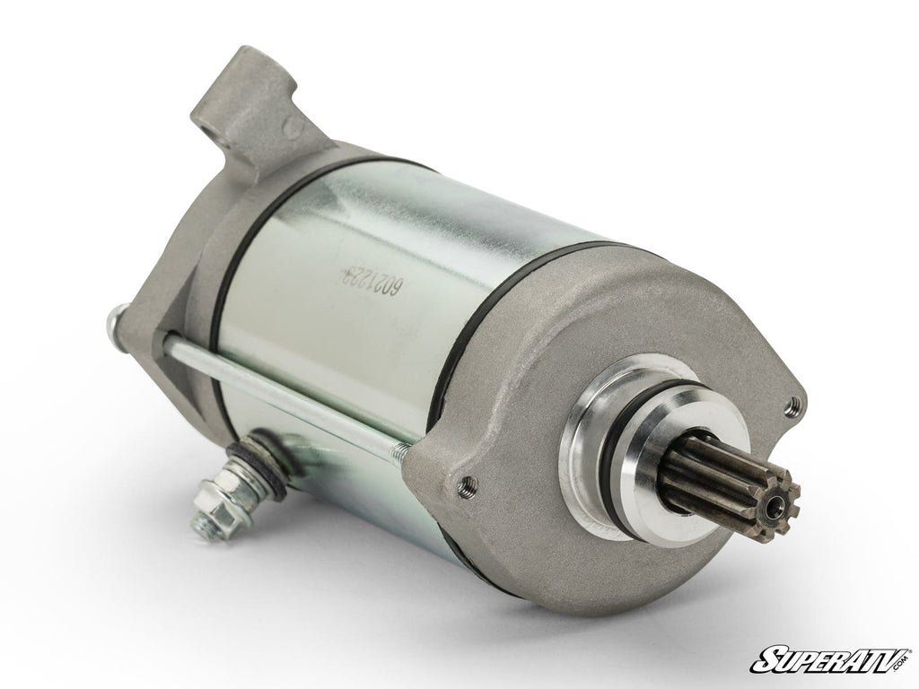 The Up & Running Yamaha Grizzly Starter features a metallic cylindrical silver body, gray mounting flanges, exposed gear, and two electrical connection bolts. The SuperATV logo is in the lower right on a white background.