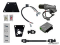The image displays the Yamaha Wolverine Power Steering Kit, featuring a motor with wiring, a SuperATV control box, mounting brackets, wiring harnesses, connectors, U-joints, bolts, hardware packets, and a steering shaft.
