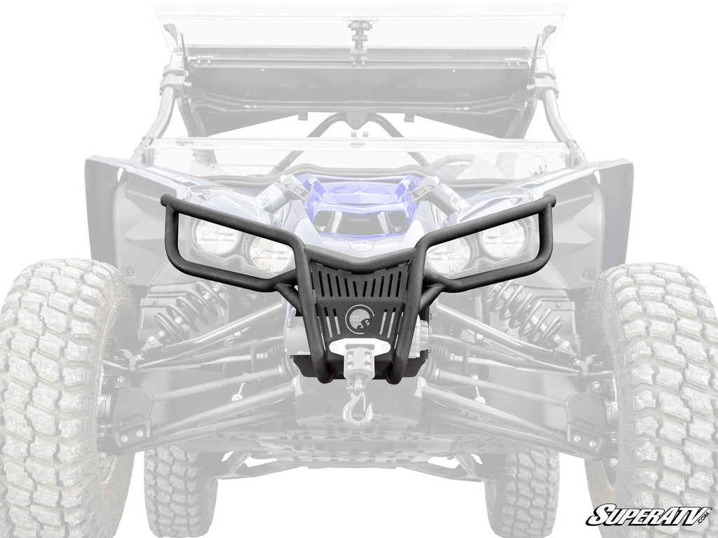 The Yamaha YXZ Front Bumper, in black with an angular design, winch mount, and grille guard, featuring the SuperATV logo, is shown over a grayscale off-road vehicle image with visible large tires and suspension.