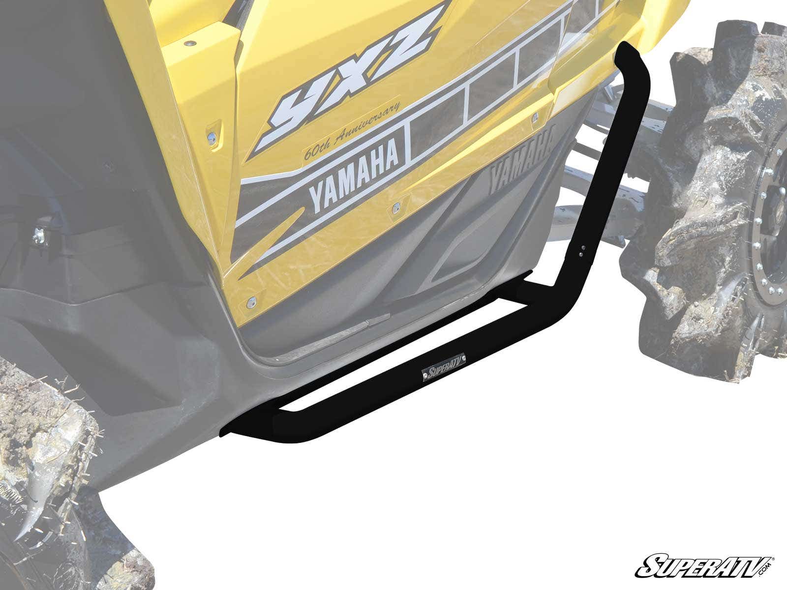 A yellow Yamaha YXZ is shown from the side, featuring black Yamaha YXZ Heavy Duty Nerf Bars along the lower edge for protection. Muddy rear wheels are partially visible, and the SuperATV logo appears in the lower right corner.