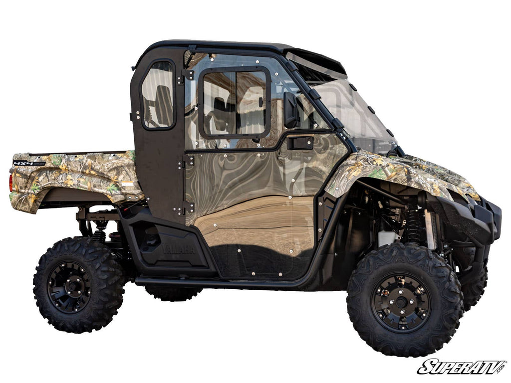 Side view of a Yamaha Viking with Convertible Cab Enclosure Doors, featuring a fully enclosed cabin, rugged off-road tires, black metal frame, and clear windows. The vehicle is on a white background with SuperATV branding in the bottom right.