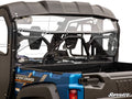A close-up of a Yamaha Viking with a clear Yamaha Viking Rear Windshield installed, showing the roll cage, seating, and highlighting the windshield’s fit and mounting hardware on the vehicle’s rear.