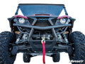 A front-facing Yamaha Wolverine X2 850 with large rugged tires, black grille, visible suspension, red winch strap, and red body on a white background. The SuperATV logo appears bottom right. Features the Winch Mounting Plate.