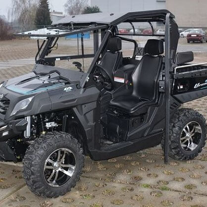 A Full Hard Cab Enclosure by Hard Cabs is installed on a 2015-20 CF Moto Uforce 500 | 800 side-by-side utility vehicle, shown parked outdoors with rugged tires, bucket seats, safety belts, roll cage, and cargo bed.