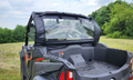 A CFMOTO ZForce 800 Trail equipped with the Door/Rear Window Combo (Upper Doors) is parked on grass amid trees under a partly cloudy sky. The cargo bed is empty, and safety labels are visible inside.