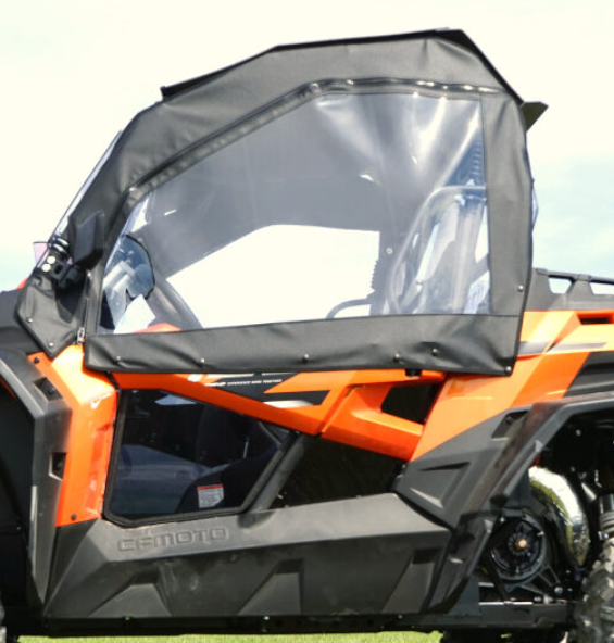 Close-up of the Soft Door Kit for CF Moto Z Force 500, 800, 800 EX, and 1000 installed on an orange off-road utility vehicle with a black frame and transparent zippered windows, highlighting its rugged design parked on grass in daylight.